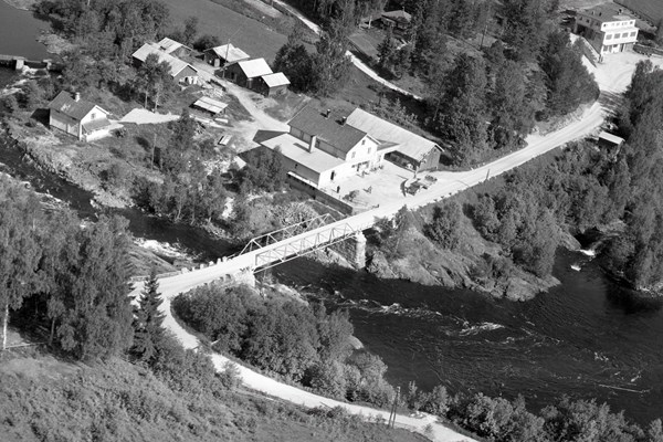 Her ser du et bilde av Handelslaget i Prestfoss fra 1953. Hva holdt til i huset helt til venstre i bildet?